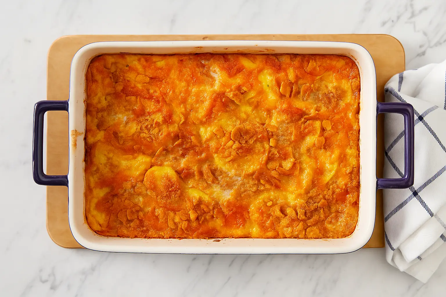 Cheesy squash casserole with golden Ritz cracker topping in a white casserole dish