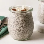 Chia pudding in a jar topped with coconut flakes and raisins.