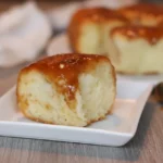 Best caramel rolls — golden rolls drenched in sticky brown sugar caramel in a baking pan.