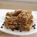Homemade granola bars with oats, coconut and peanut butter cut into bars on parchment.
