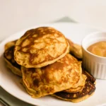 Stack of paleo banana almond flour pancakes with berries and almond butter.