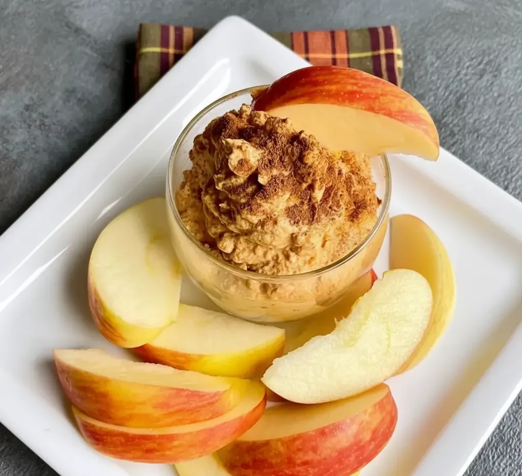 Pumpkin yogurt fluff served in small glass bowls with a ginger snap on the side.