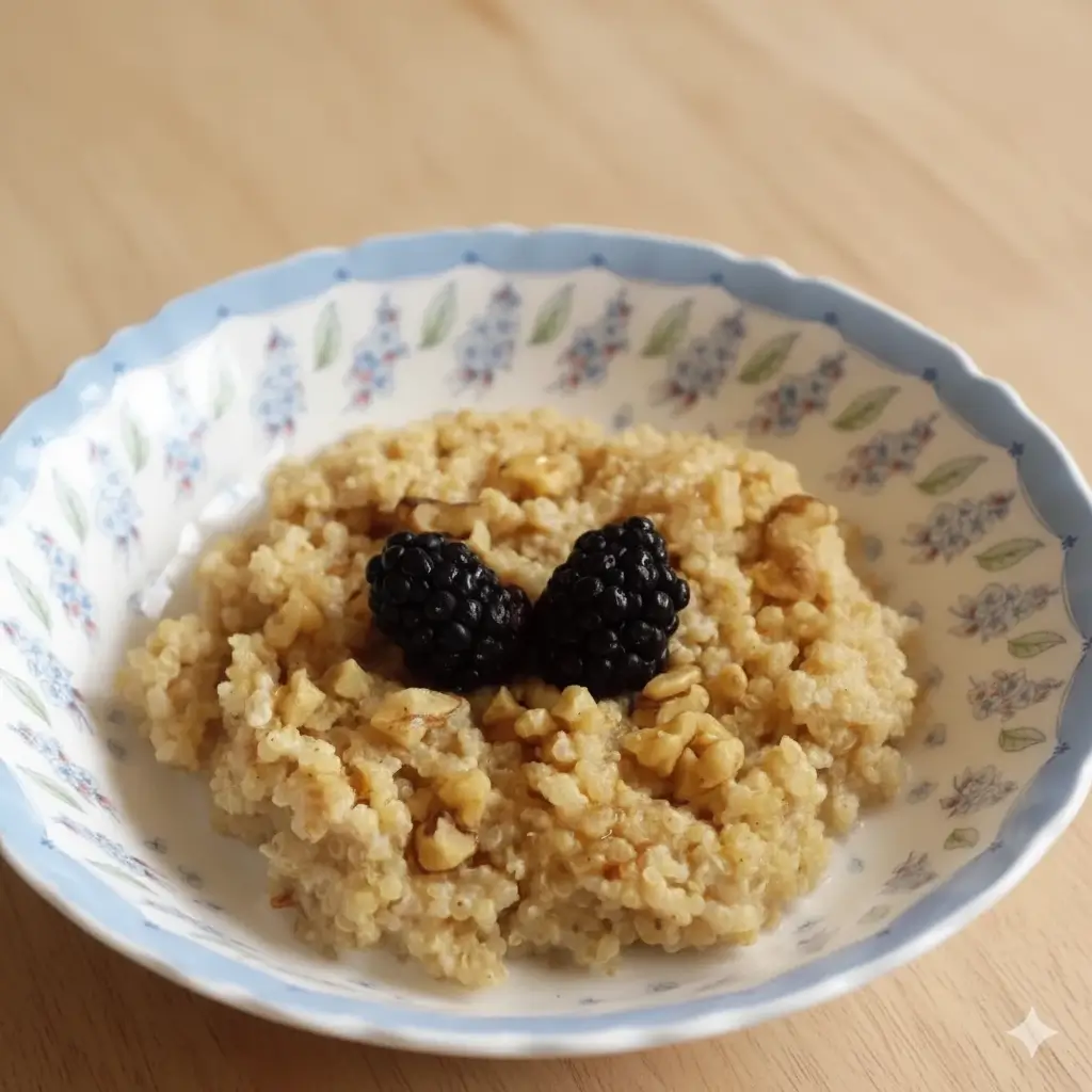 Bowl of warm quinoa porridge topped with cinnamon and sliced fruit.