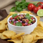 Colorful Texas caviar with black-eyed peas, black beans, tomatoes, jalapeños, and cilantro in a bowl.