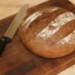 Sliced loaf of homemade Dark Rye Bread with rich brown color and soft texture
