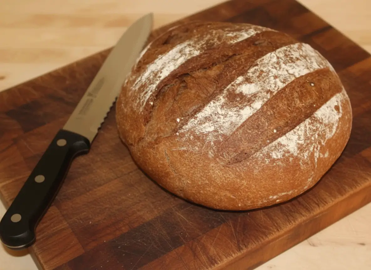 Sliced loaf of homemade Dark Rye Bread with rich brown color and soft texture