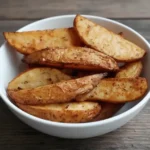 Crispy Cajun Potato Wedges on a baking tray with spicy seasoning